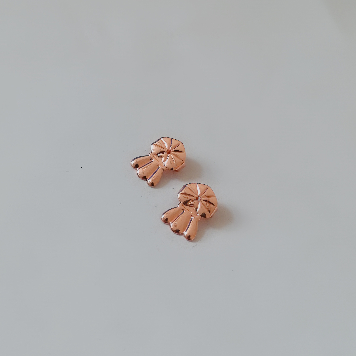 A pair of rose gold-plated PE bags