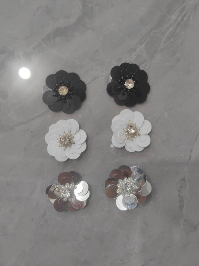 Two sequined flowers each of silver + white + black