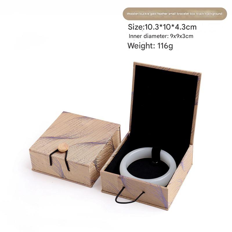 A small woodblock gold feather bracelet box